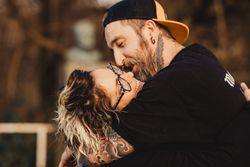 Happy couple hugging near tree in park