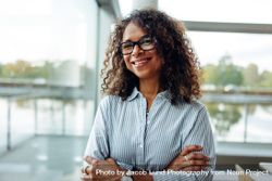 Portrait of female professional with curly hair wearing eyeglasses 0LDGA0