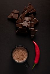 Chocolate near mug with hot drink and pepper