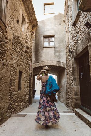 Woman walking in a narrow path in a village