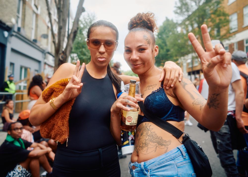 London, England, United Kingdom - August 28, 2022: Two female friends with liquor bottle outside