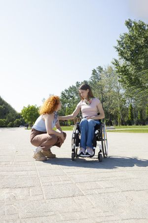 Woman with a disability chatting to her friend outside