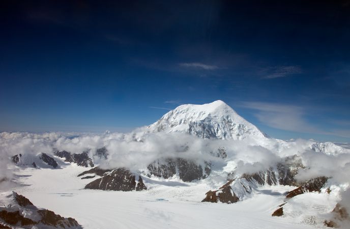 Snowy peak of Mount Foraker shrouded in clouds in Alaska