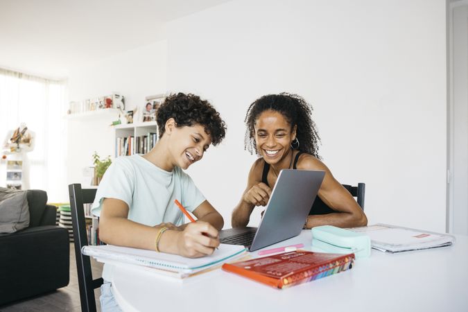 Girl doing her homework with mother
