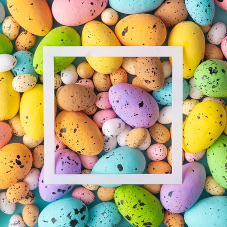 Easter composition made with colorful eggs and square outline