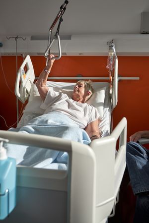Older unwell woman lying on medical bed in hospital