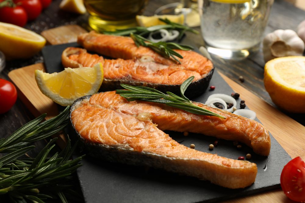 Composition with tasty grilled salmon on wooden background, close up