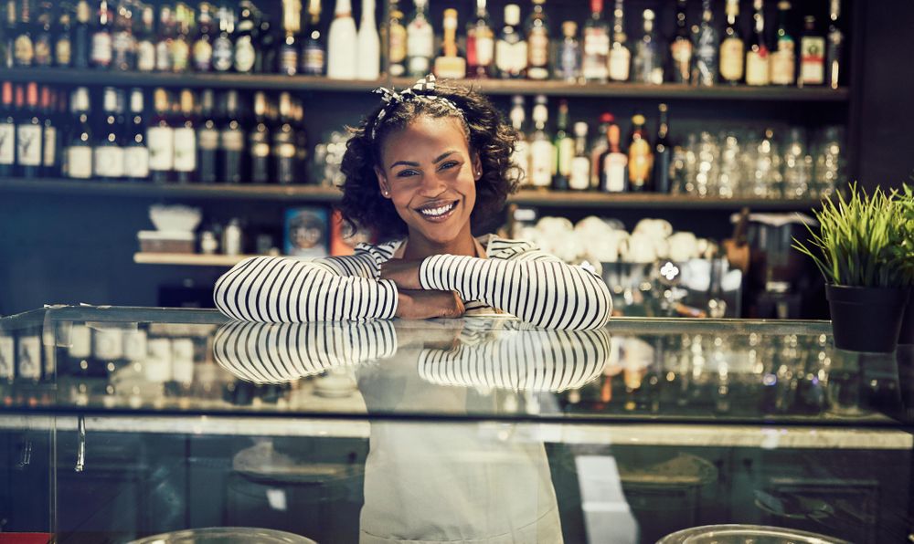 Smiling woman leaning on glass display in modern bistro