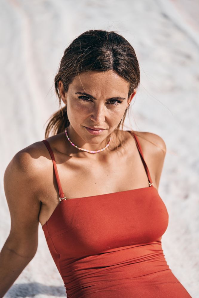 Tanned female in swimwear relaxing on salty lake shore