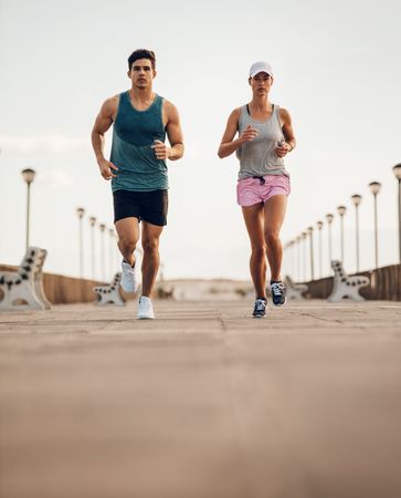 Two young people running on road