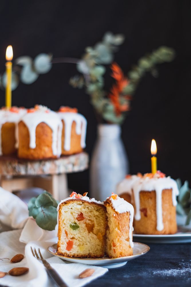 Sliced mini fruit cake on dessert plate on table with other small cakes