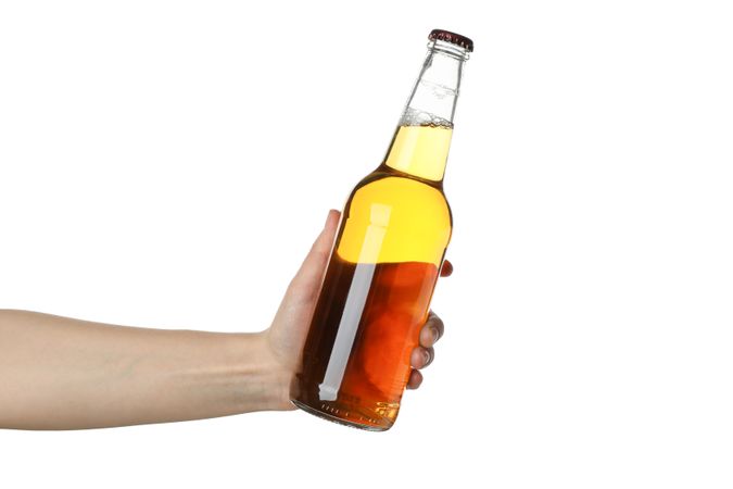 Female hand holds bottle of cider, isolated on blank background