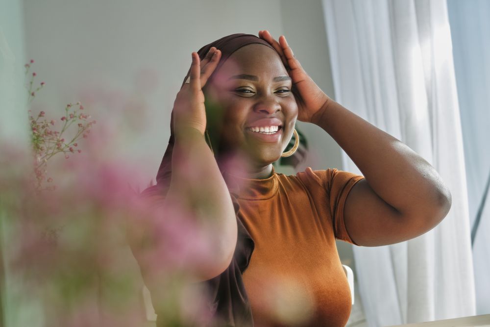 Positive Black woman putting on hijab