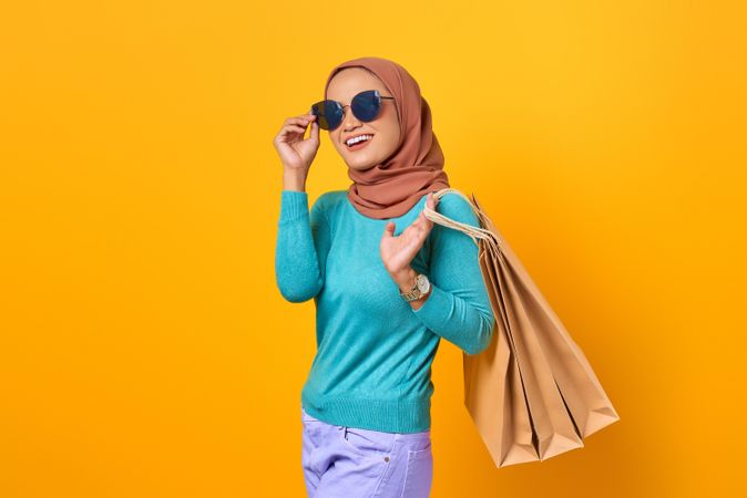 Muslim woman with sunglasses and shopping bags