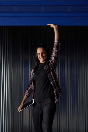 Smiling woman opening roll up door