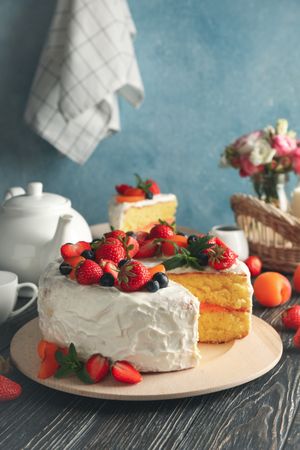 Composition with delicious berry cream cake on wooden table. Tasty dessert