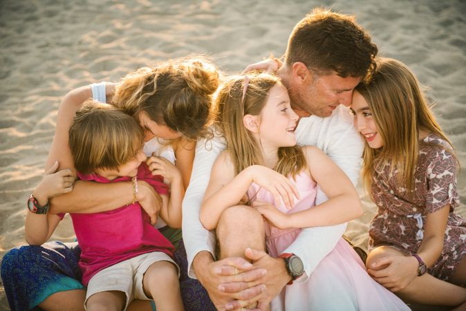 Beautiful happy family with playful children on beach