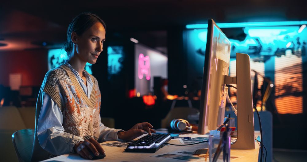 Female Talented Digital Marketing Specialist Working on Computer at Office in the Evening.
