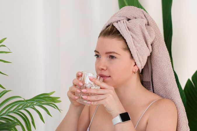 Drinking water during skincare routine.