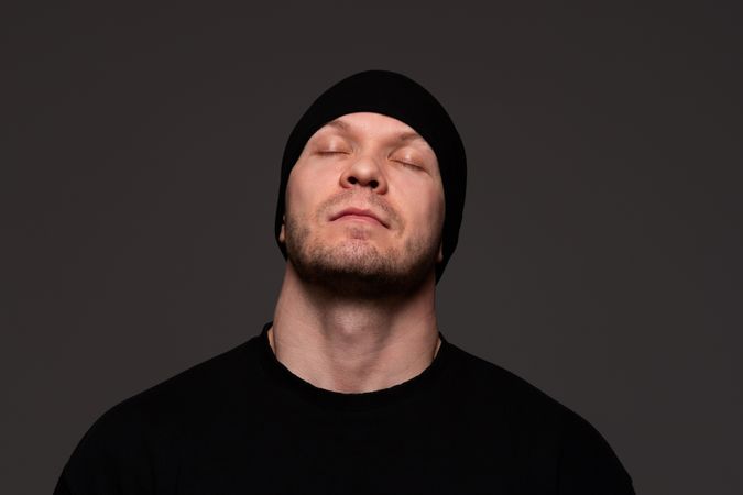 Man in beanie and sweatshirt with closed eyes