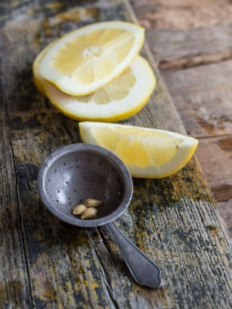 Lemon slice and stainer placed on wooden board