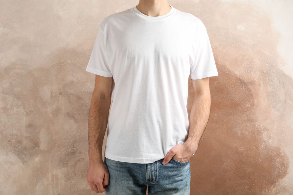 Men in blank t-shirt against brown background, space for text