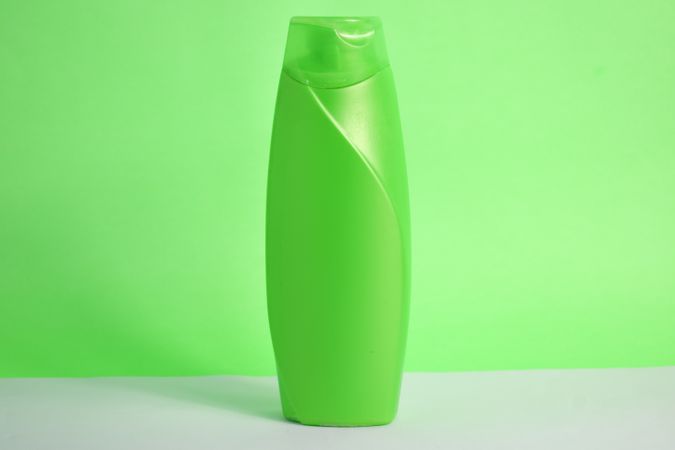 Green body wash bottle without labels on counter in green room