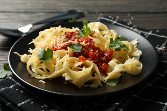 Composition with plate of tasty pasta on wooden background