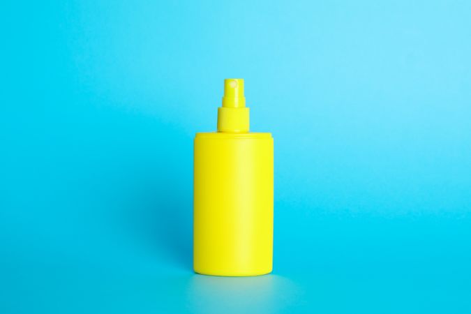Sunscreen spray on color background, space for text