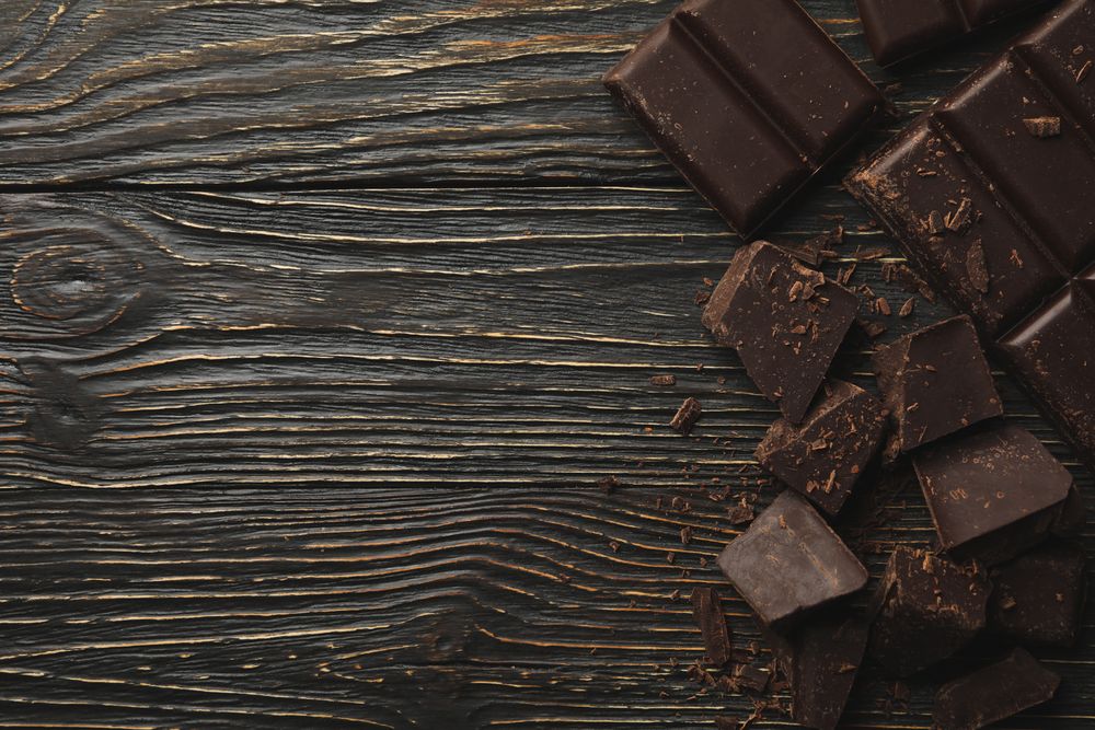 Tasty chocolate on wooden background, top view