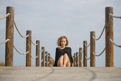 Young woman sitting on footbridge
