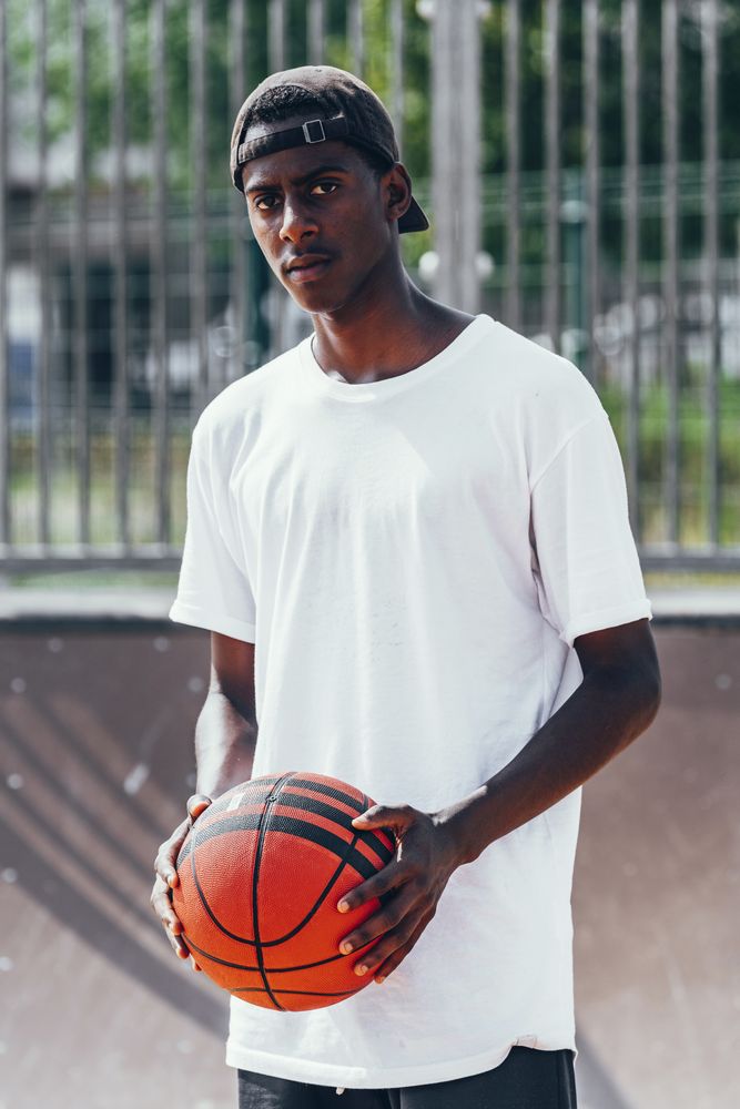 Black sportsmen with ball and looking at camera