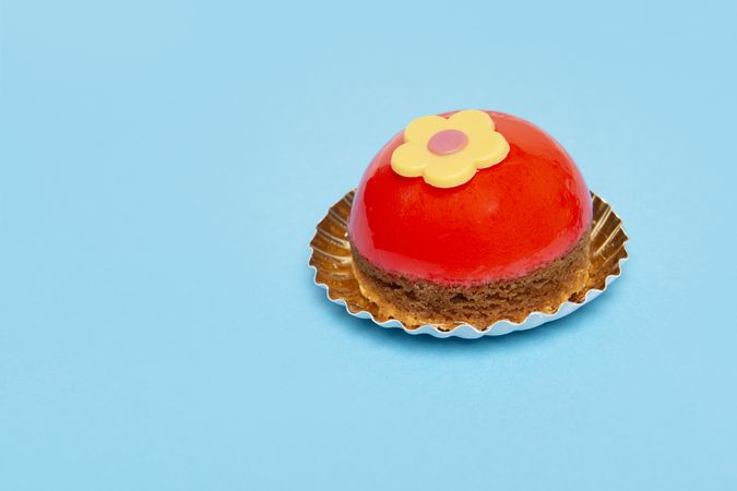 Delicious looking small round red cake on a blue background