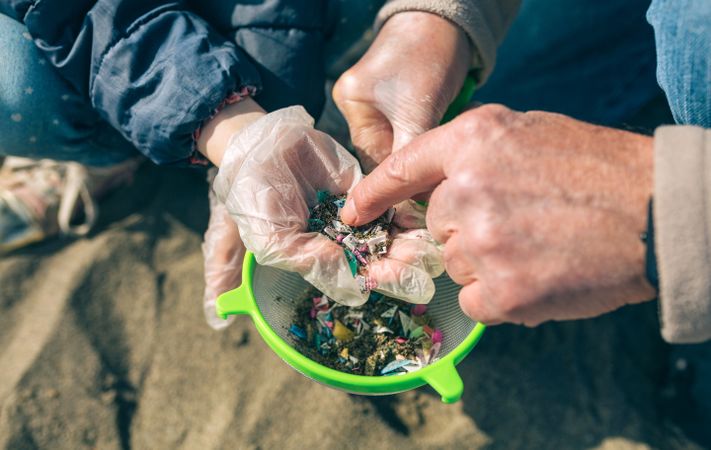 Colander with microplastics on the beach