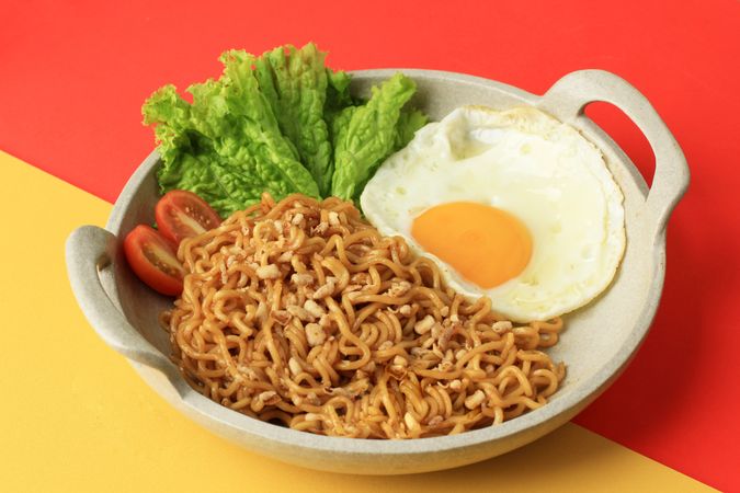 Indomie goreng, Indonesian noodles and egg on duotone background