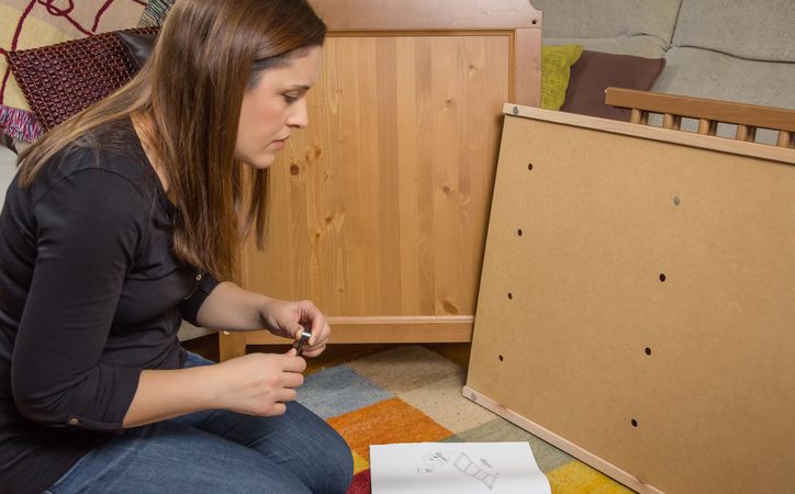 Woman reading instructions to assemble furniture