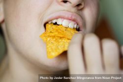 Girl biting nacho chips bDj2Ry