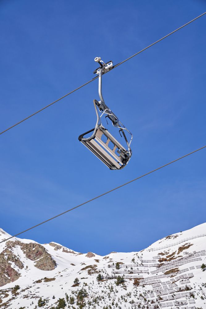 Ropeway in snowy mountains on cloudless day