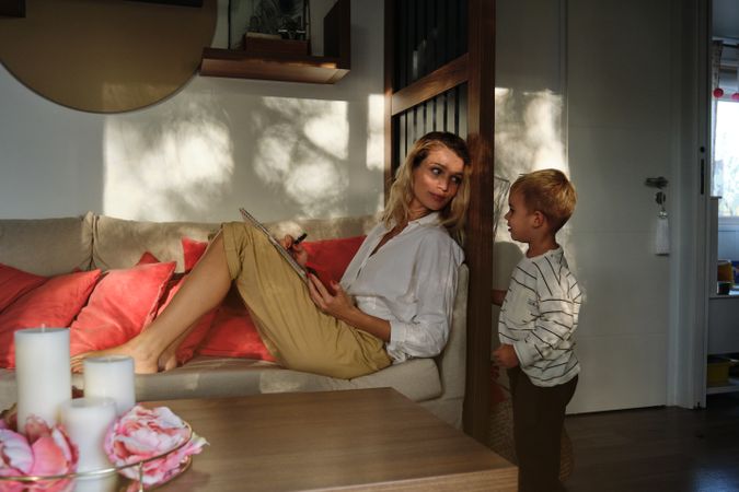 Mother relaxing on couch and looking at son