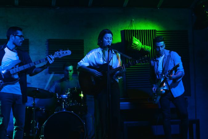 Musicians In Stage With Colorful Lights Performing In A Live Concert