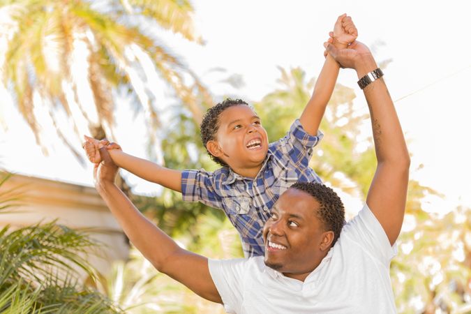 Black Father and Son Playing Piggyback On Sunny Day