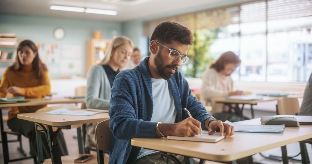 Multiethnic Indian Man Acquiring New Academic Skills in Classroom with Other People.