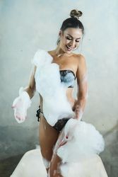 Smiling woman n dark bikini standing in foamy bath