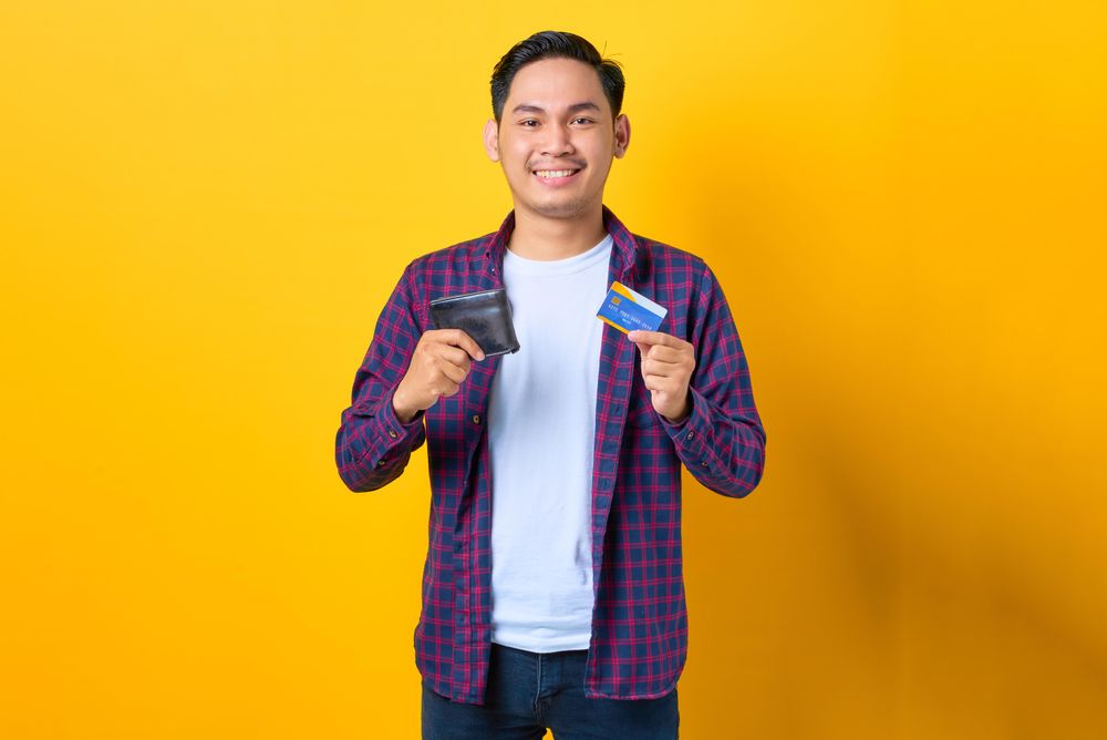 Man holding up wallet and credit card