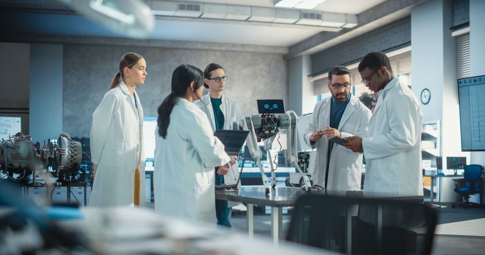 Engineers In Lab Coats Discussing an Automated AI Robotic Dog, Using Laptop and Tablet, Brainstorming