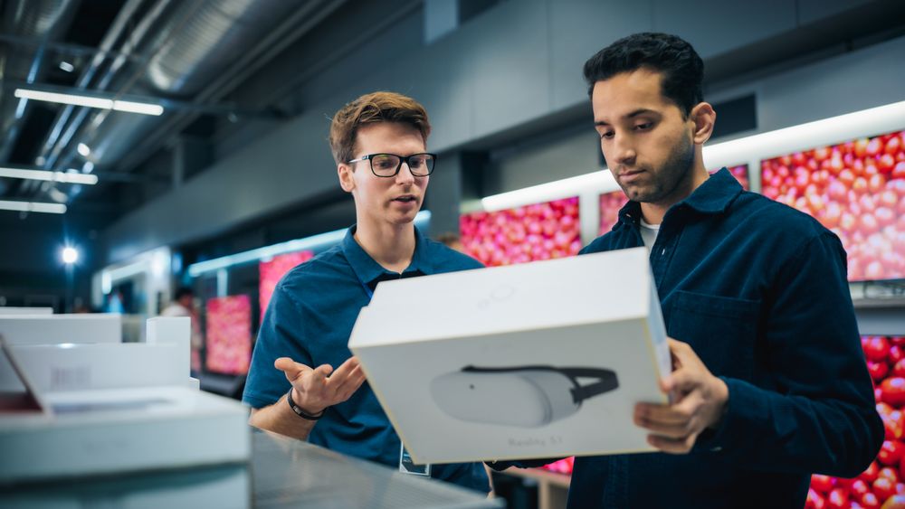 Young Multiethnic Customer Advising with Retail Home Electronics Store Salesperson.