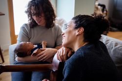Female couple cradling baby to sleep