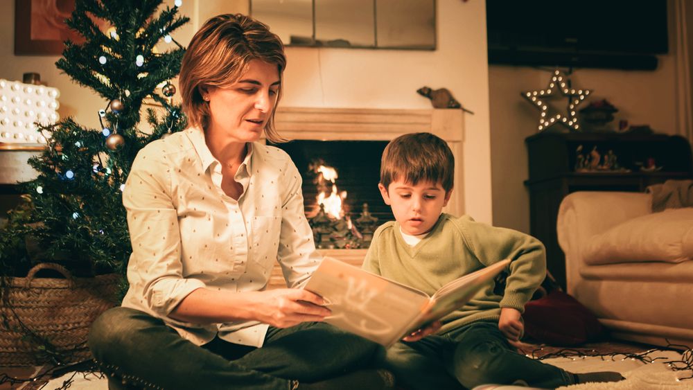 Mother reading book with son on Christmas eve