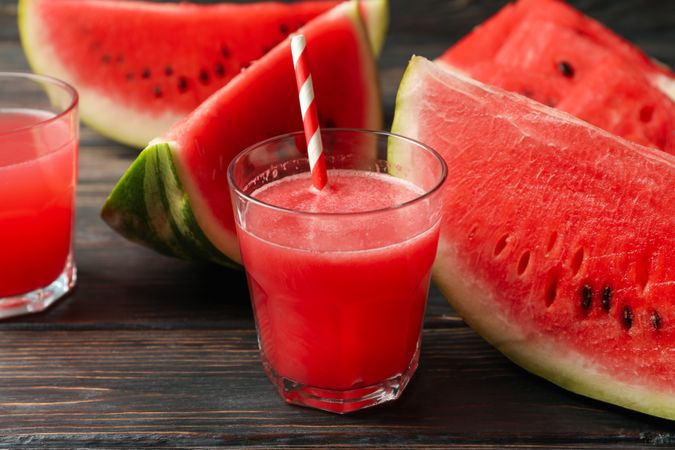 Composition with watermelon slices and juice on wooden background. Summer fruit
