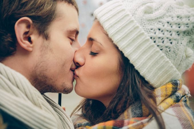 Side view of couple kissing on cold day